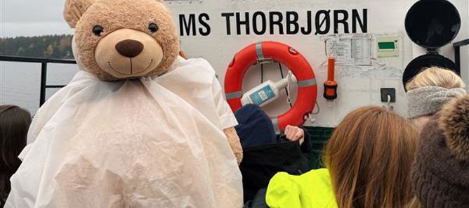 en bamse og elever på båt en bamse og elever på båt