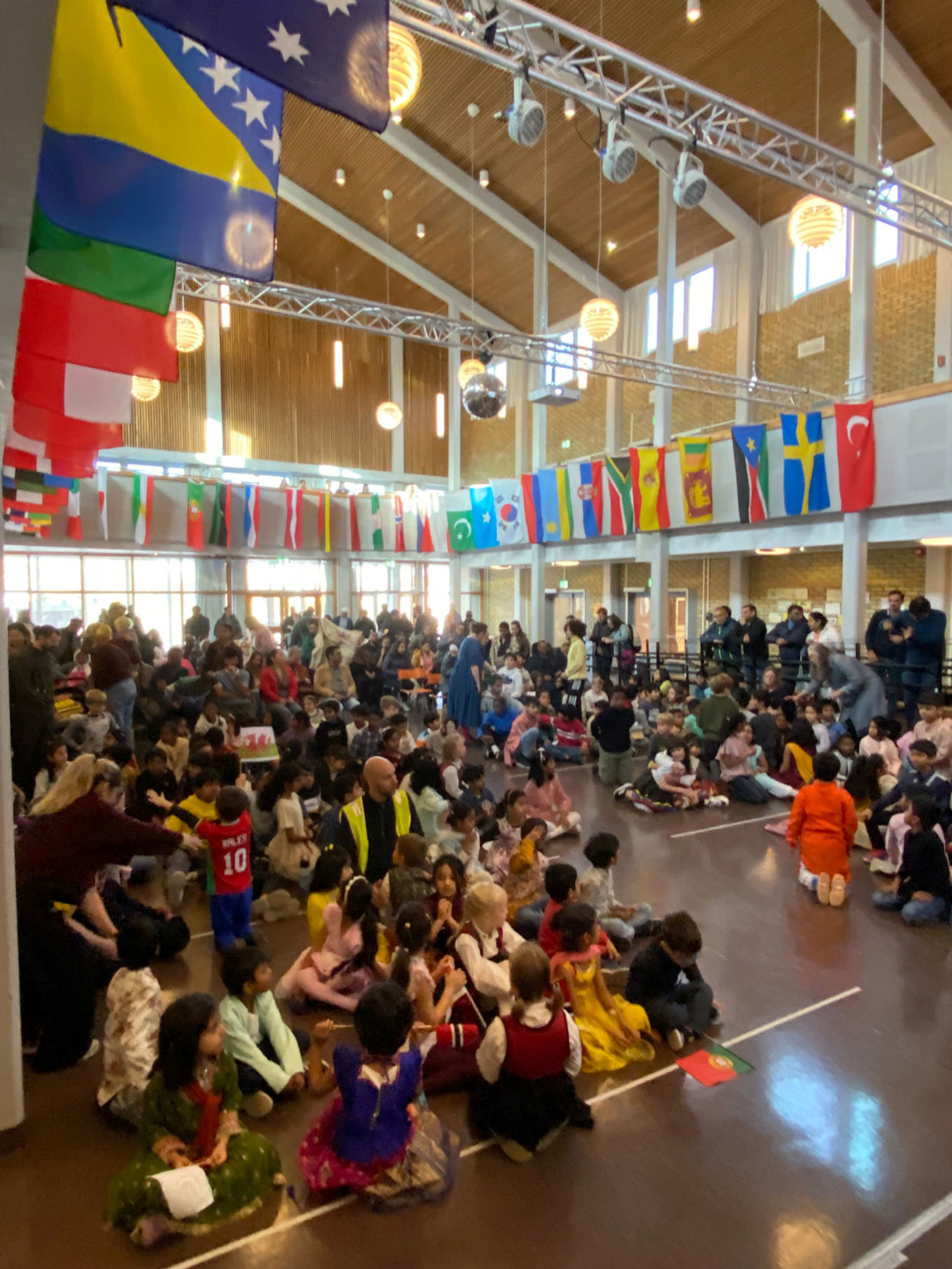 En gruppe mennesker som sitter i en sal med flagg